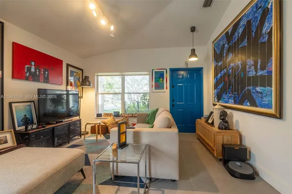 a living room with furniture a flat screen tv and a window
