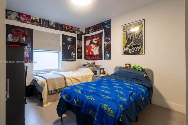 a bedroom with two beds and painting on the wall