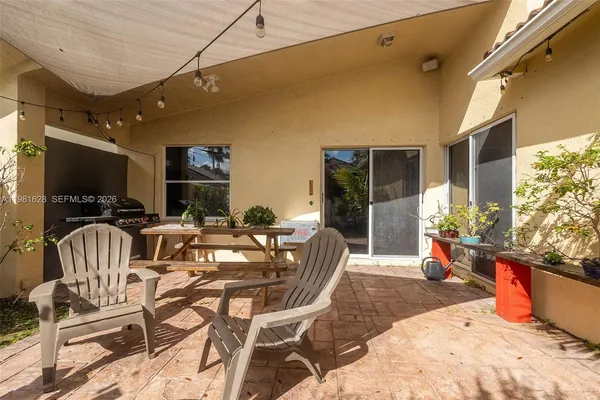 a outdoor space with furniture a flat screen tv and potted plants