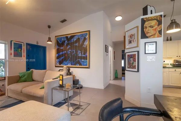 a living room with furniture and paintings on the wall