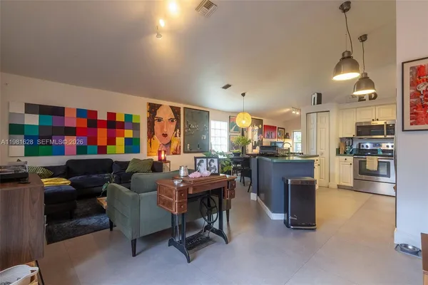 a living room with fireplace furniture and a kitchen