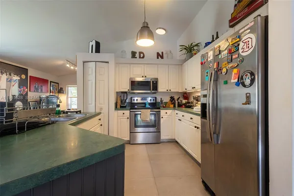 a kitchen with stainless steel appliances granite countertop a refrigerator and a stove top oven