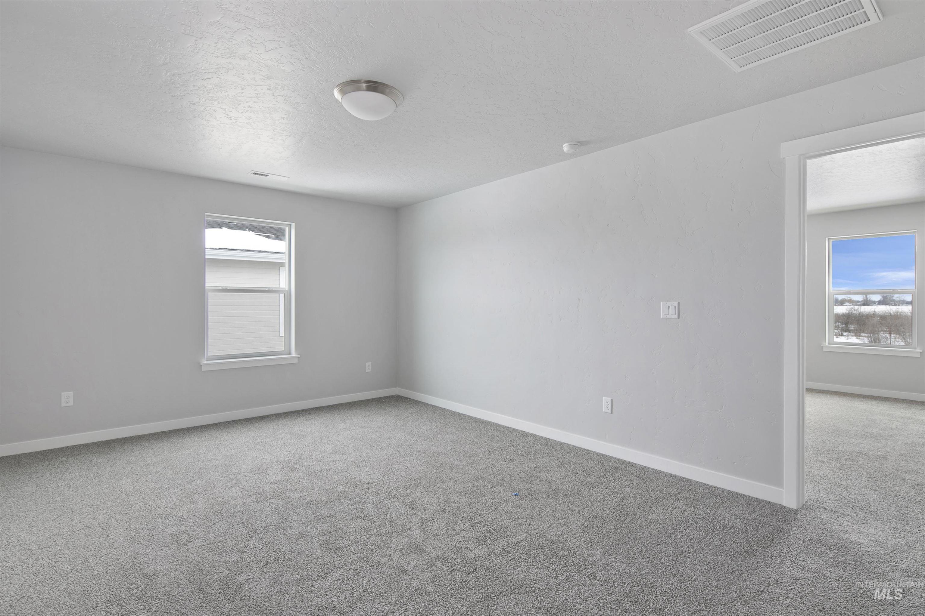 456 South Bobby Way Kuna, ID 83634 - Photo 8 of 10 Empty room with light colored carpet and a textured ceiling