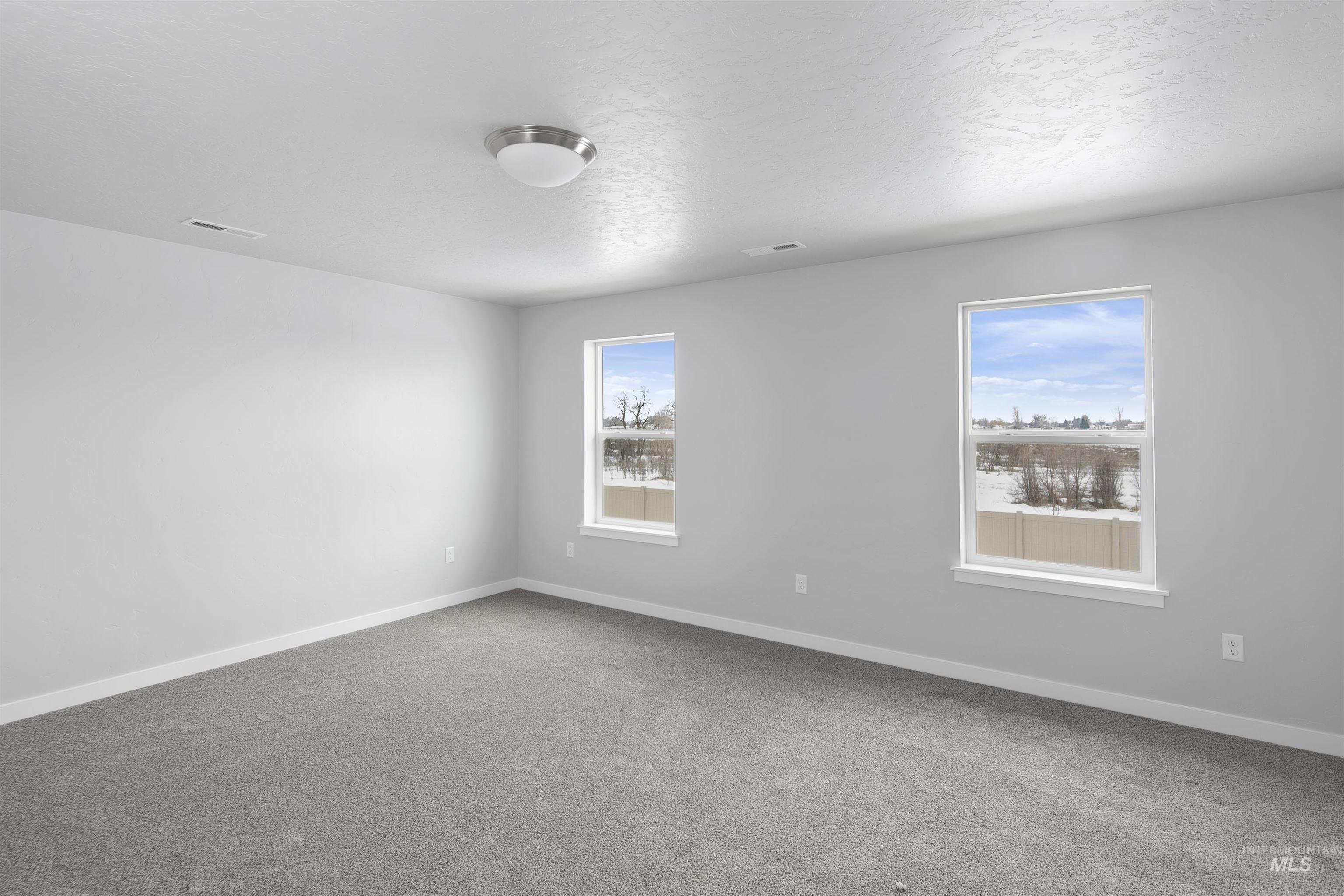 456 South Bobby Way Kuna, ID 83634 - Photo 9 of 10 Carpeted empty room with baseboards and a textured ceiling