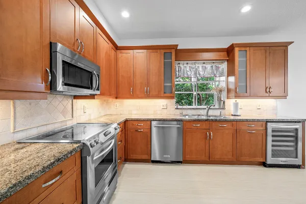 a kitchen with stainless steel appliances granite countertop a stove a sink and a microwave