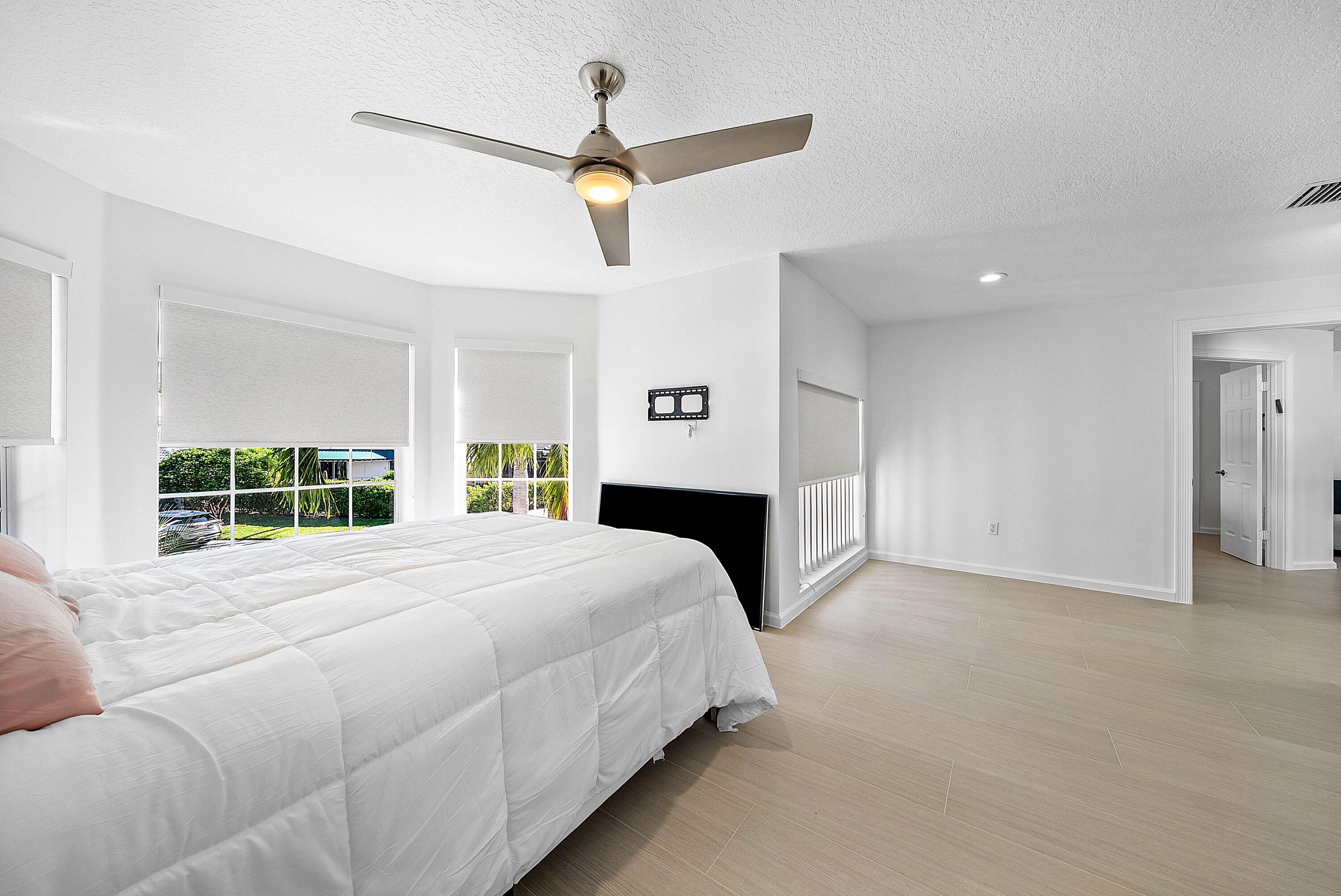 5855 Northwest 42nd Way Boca Raton, FL 33496 - Photo 30 of 77 a spacious bedroom with a large bed chandelier and a window