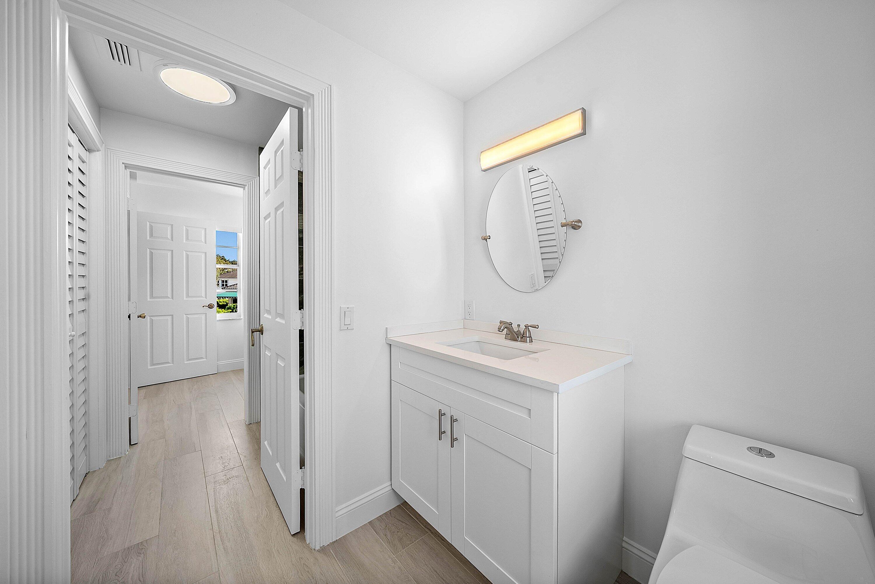 5855 Northwest 42nd Way Boca Raton, FL 33496 - Photo 33 of 77 a view of bathroom with a toilet a sink and a mirror