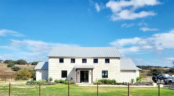 a view of a white house with a yard