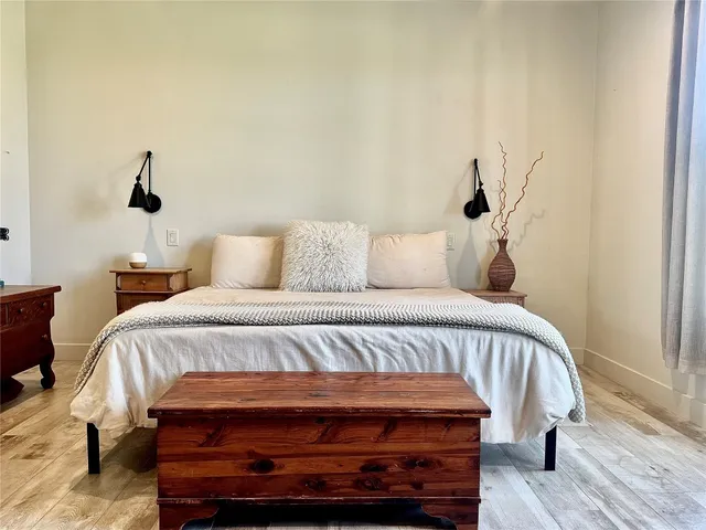 a bedroom with a bed and a wooden floor