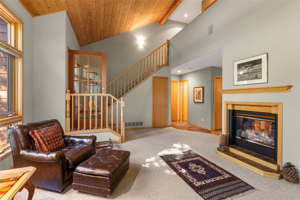 91 Riverside Place Frisco, CO 80443 - Photo 13 of 43 Living area featuring carpet flooring, stairway, a glass covered fireplace, beam ceiling, and high vaulted ceiling