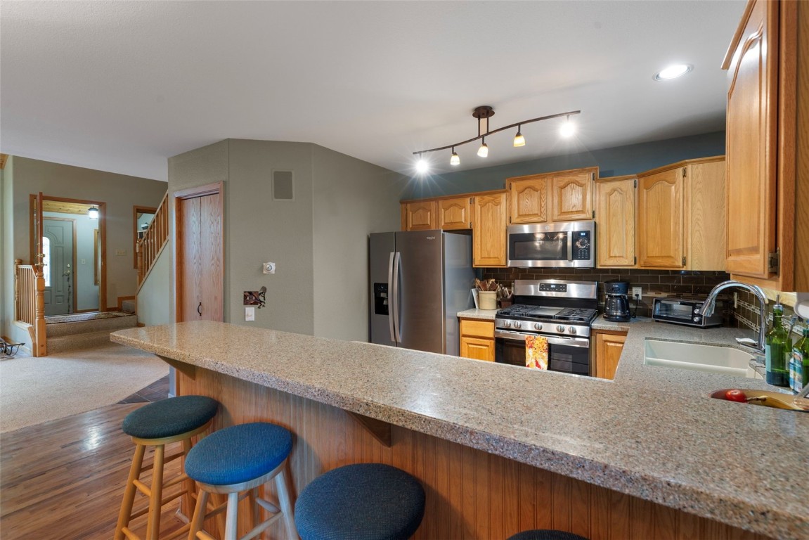 91 Riverside Place Frisco, CO 80443 - Photo 18 of 43 Kitchen featuring stainless steel appliances, light countertops, tasteful backsplash, and a peninsula