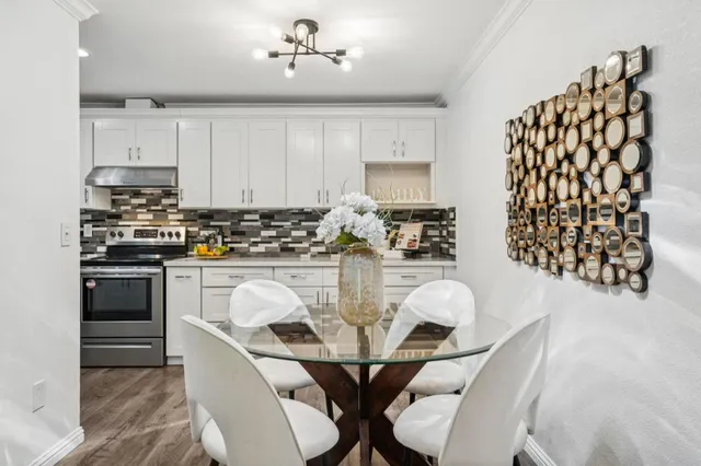 a kitchen with stainless steel appliances granite countertop a white table and chairs
