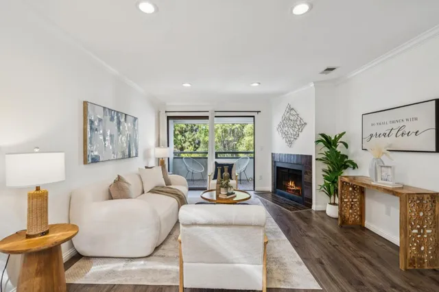 a living room with furniture a fireplace and a potted plant