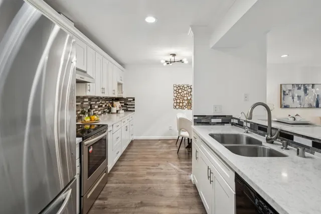a kitchen with stainless steel appliances granite countertop a sink and a refrigerator