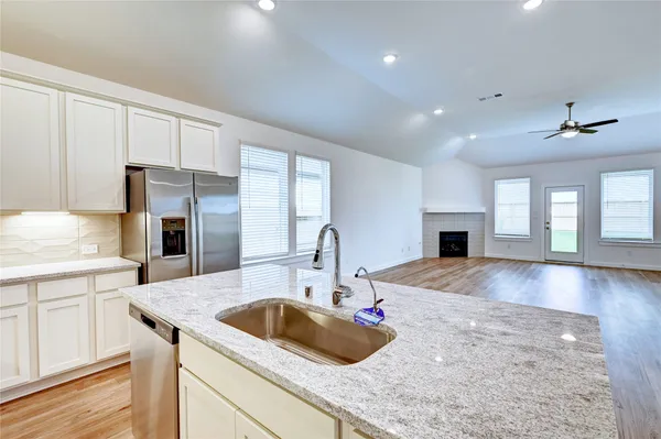 a kitchen with granite countertop a sink a counter top space appliances and cabinets