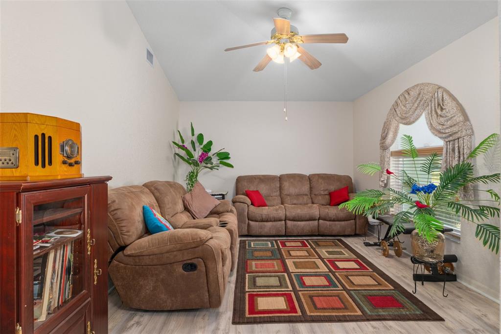 2104 Linwood Avenue Spring Hill, FL 34608 - Photo 13 of 44 a living room with furniture rug and a chandelier