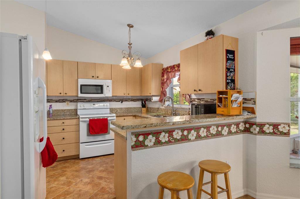 2104 Linwood Avenue Spring Hill, FL 34608 - Photo 16 of 44 a kitchen with stainless steel appliances granite countertop a sink stove and refrigerator