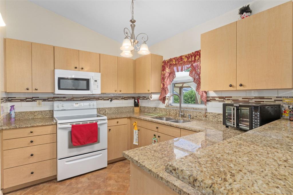 2104 Linwood Avenue Spring Hill, FL 34608 - Photo 17 of 44 a kitchen with stainless steel appliances granite countertop a stove a sink and a microwave