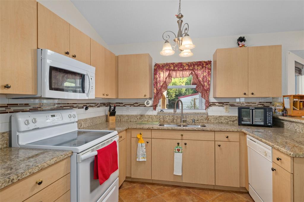 2104 Linwood Avenue Spring Hill, FL 34608 - Photo 19 of 44 a kitchen with stainless steel appliances granite countertop a sink stove and cabinets