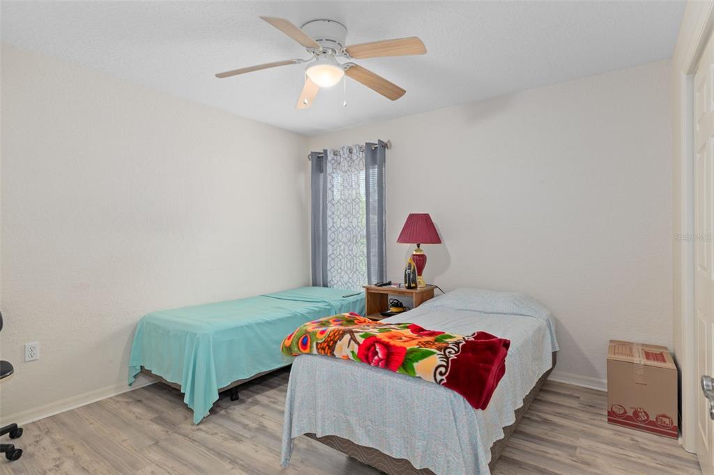 2104 Linwood Avenue Spring Hill, FL 34608 - Photo 26 of 44 a bedroom with a bed and a chandelier