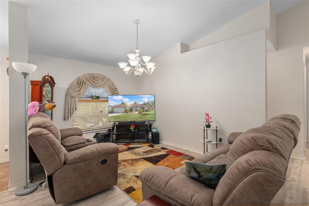 2104 Linwood Avenue Spring Hill, FL 34608 - Photo 10 of 44 a living room with furniture kitchen view and a chandelier