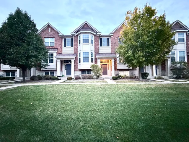 a view of a house with a big yard plants and large trees