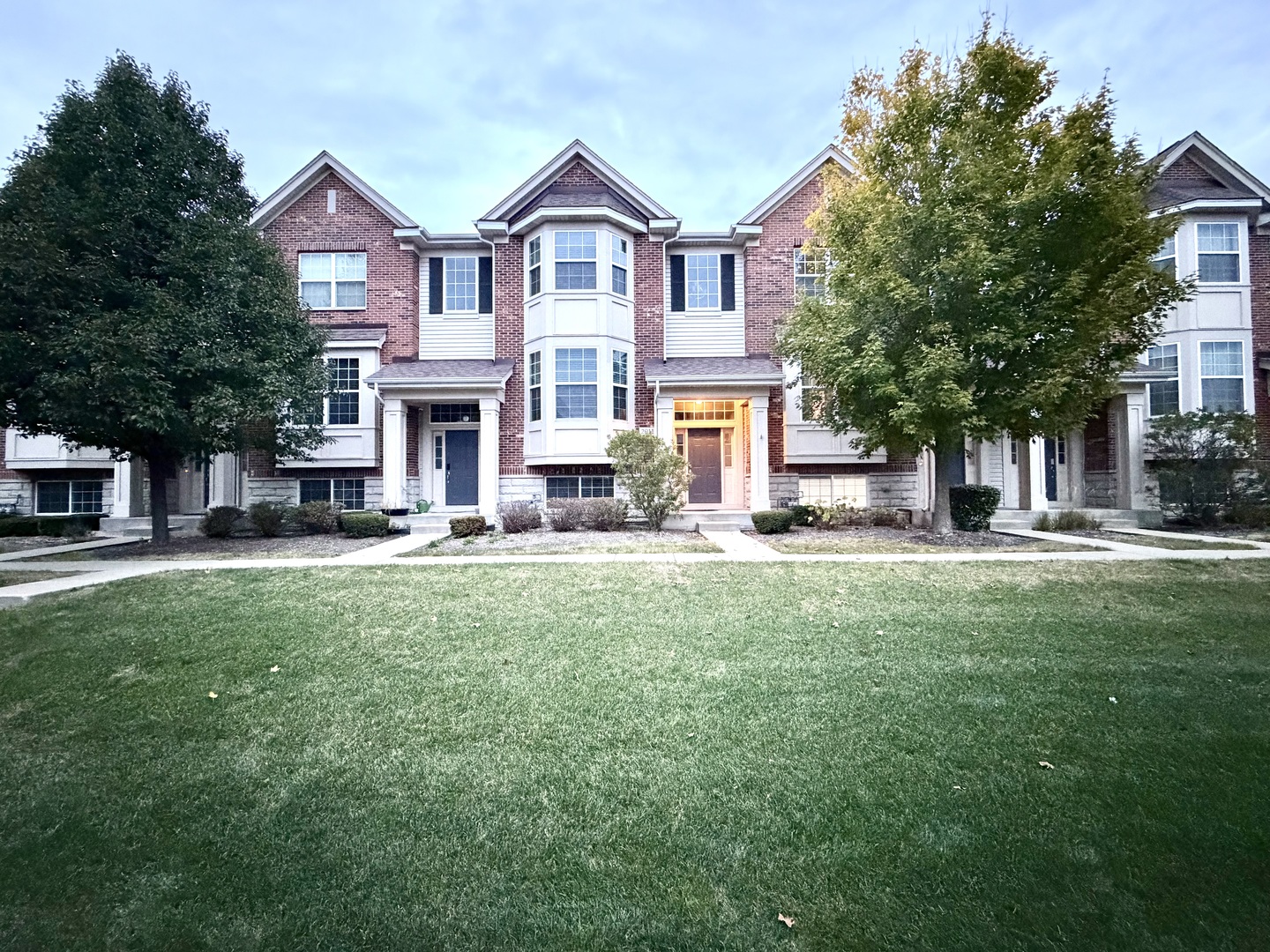 a view of a house with a big yard plants and large trees