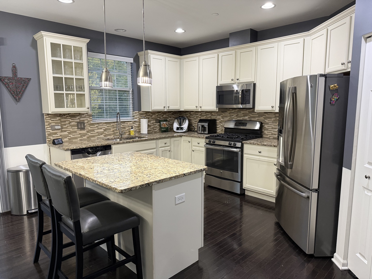 2911 Henley Lane, Unit 2911 Naperville, IL 60540 - Photo 5 of 23 a kitchen with granite countertop stainless steel appliances a refrigerator a stove a sink a dining table and chairs