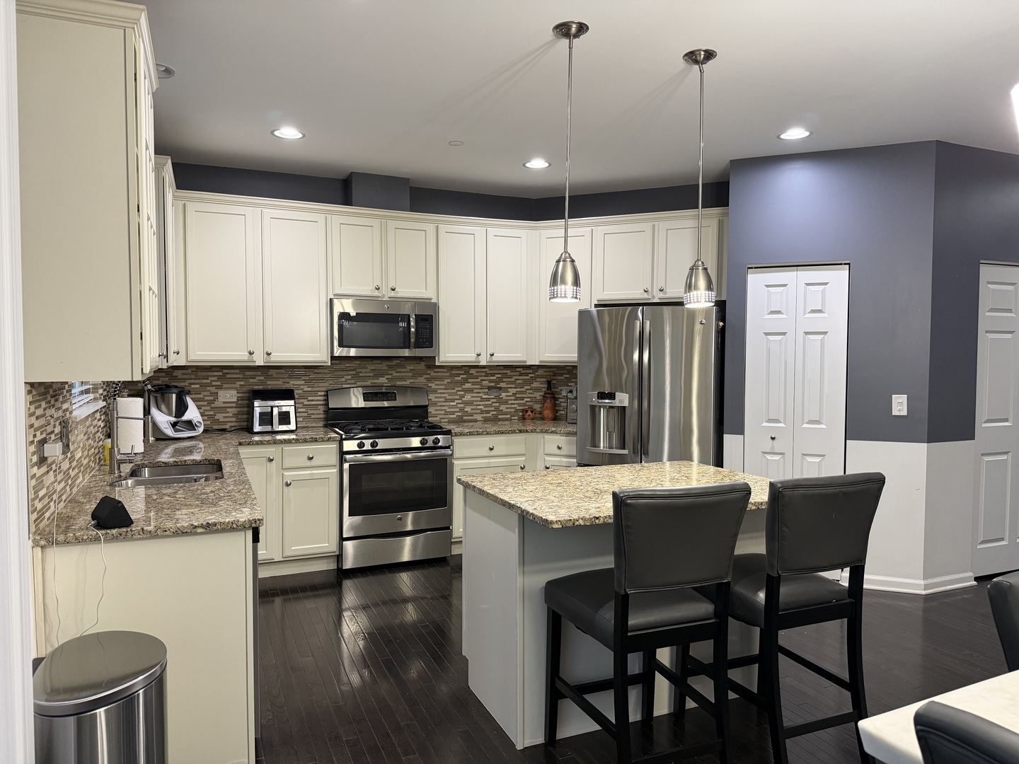 2911 Henley Lane, Unit 2911 Naperville, IL 60540 - Photo 6 of 23 a kitchen with stainless steel appliances granite countertop a stove a sink a microwave a refrigerator with a dining table and chairs