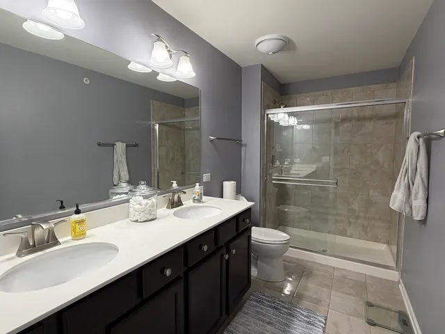 a bathroom with a double vanity sink mirror double and toilet