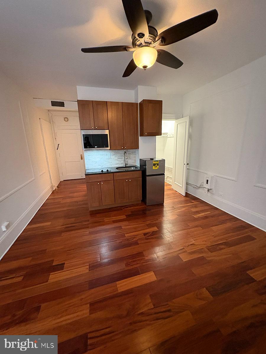 1324-00 Locust Street, Unit 1017 Philadelphia, PA 19107 - Photo 5 of 13 a view of kitchen and empty room with wooden floor