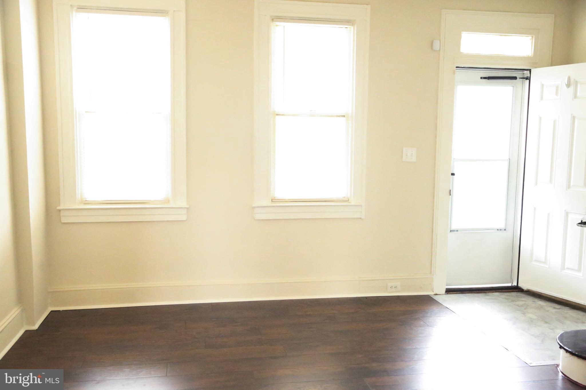 4852 Pimlico Road Baltimore, MD 21215 - Photo 3 of 40 an empty room with wooden floor and a window