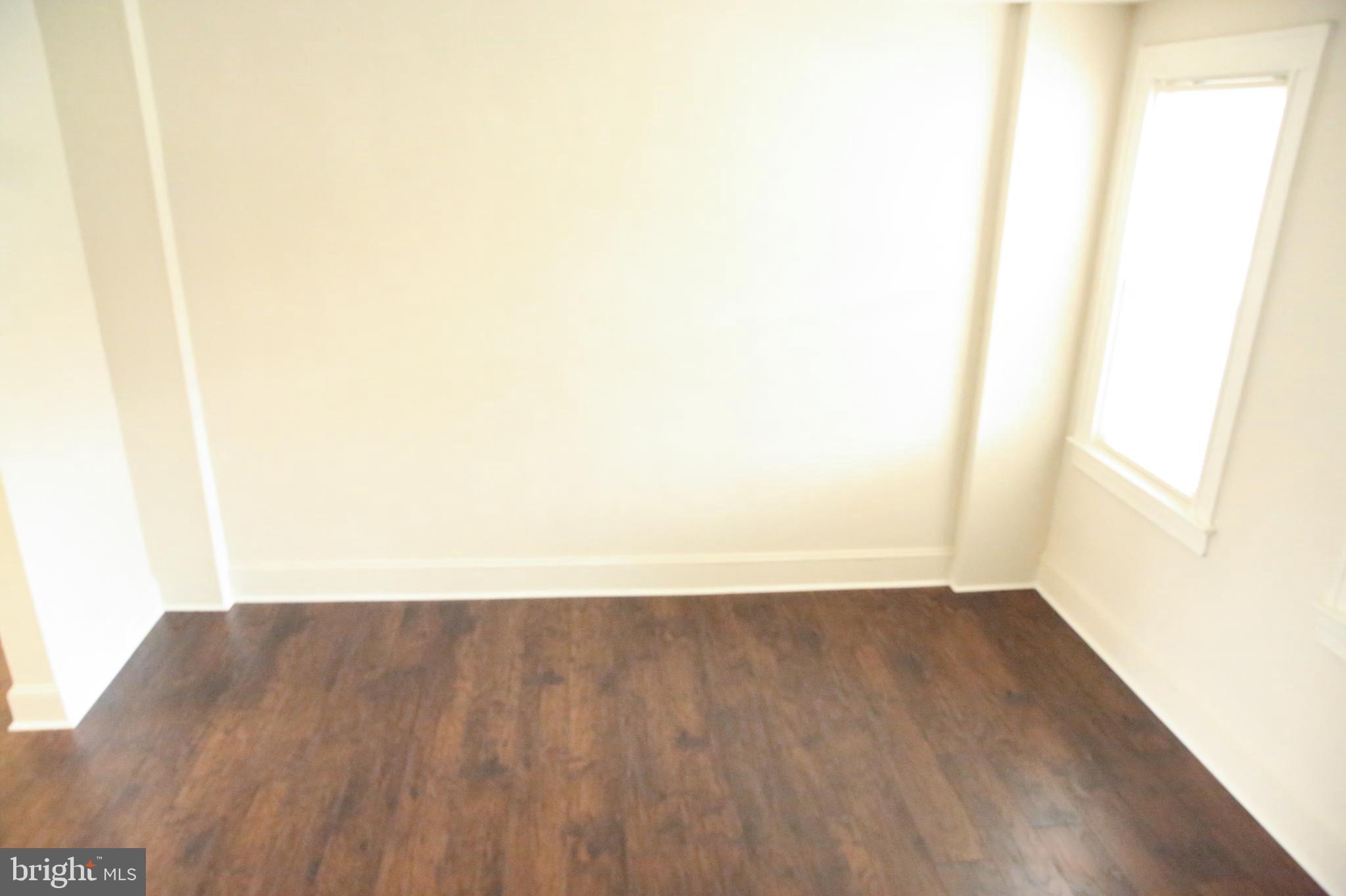 4852 Pimlico Road Baltimore, MD 21215 - Photo 4 of 40 a view of an empty room with wooden floor