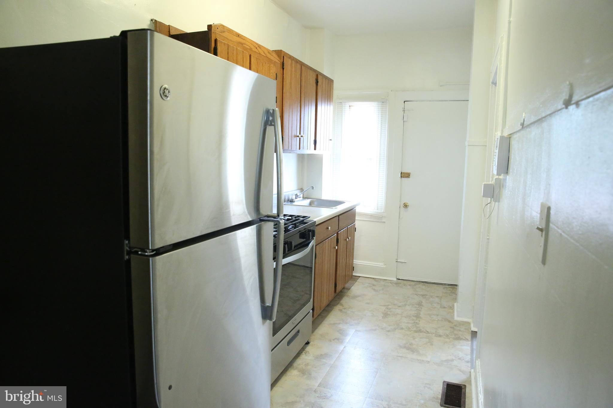 4852 Pimlico Road Baltimore, MD 21215 - Photo 9 of 40 a kitchen with stainless steel appliances a refrigerator and a cabinets