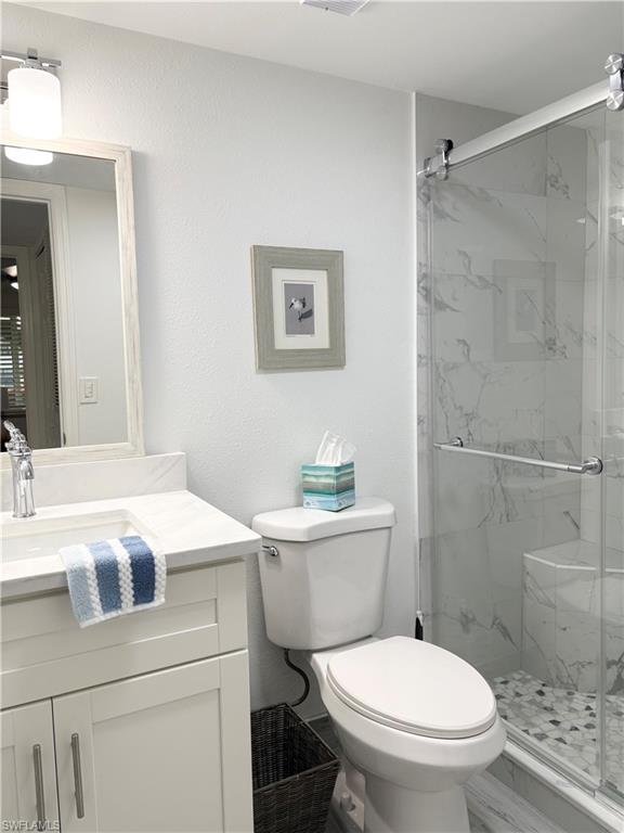 4351 27th Court Southwest, Unit 104 Naples, FL 34116 - Photo 9 of 16 a white toilet sitting next to a bathroom sink