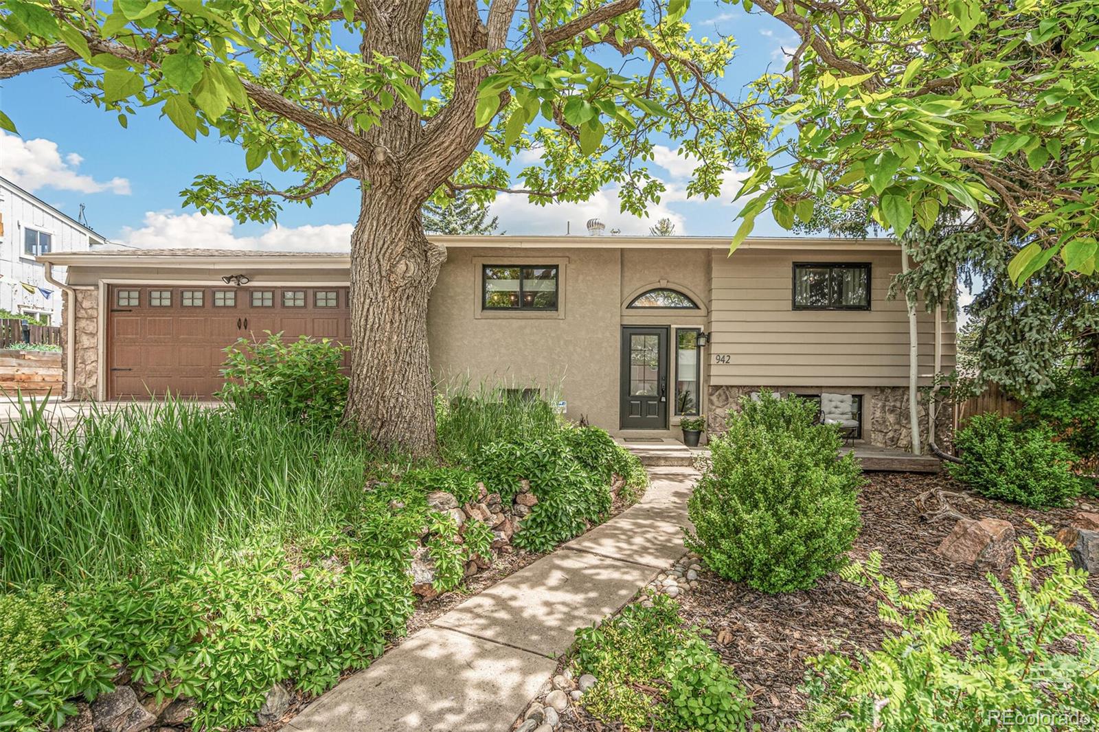 942 South Quail Way Lakewood, CO 80226 - Photo 1 of 26 a front view of house with yard and trees around