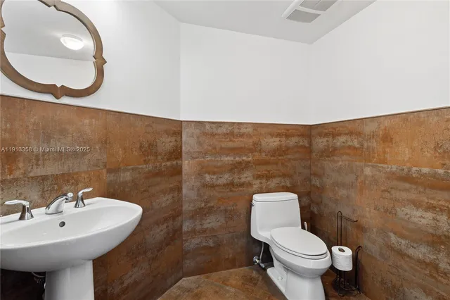 a bathroom with a sink a mirror and a toilet