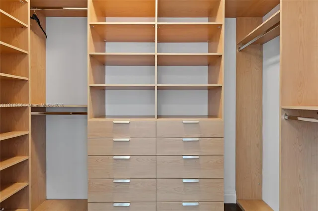 a view of walk in closet with empty racks