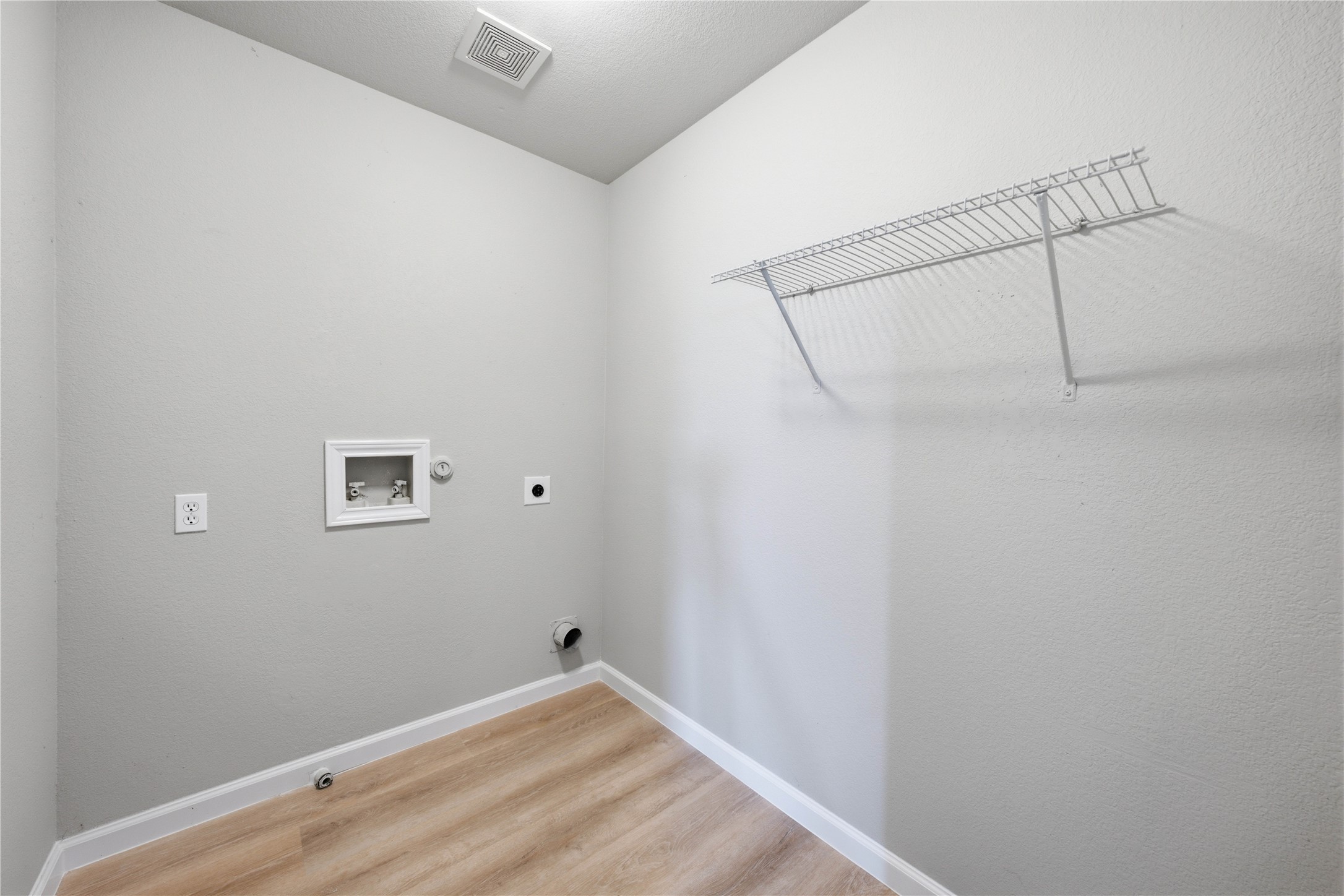 6917 Panda Royle Drive Del Valle, TX 78617 - Photo 16 of 23 A dedicated laundry room with hookups and convenient overhead shelving for organization.