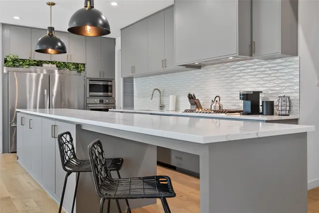a kitchen with stainless steel appliances a sink a stove and cabinets