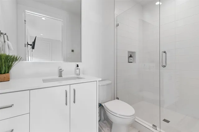a bathroom with a granite countertop sink a toilet and shower