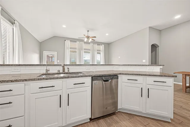 a kitchen with white cabinets and sink