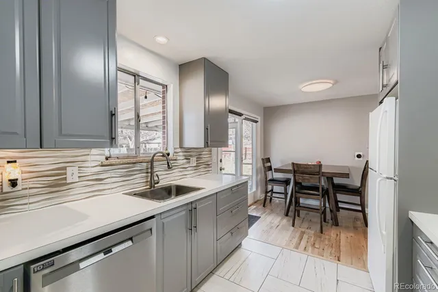 a kitchen with a sink and chairs