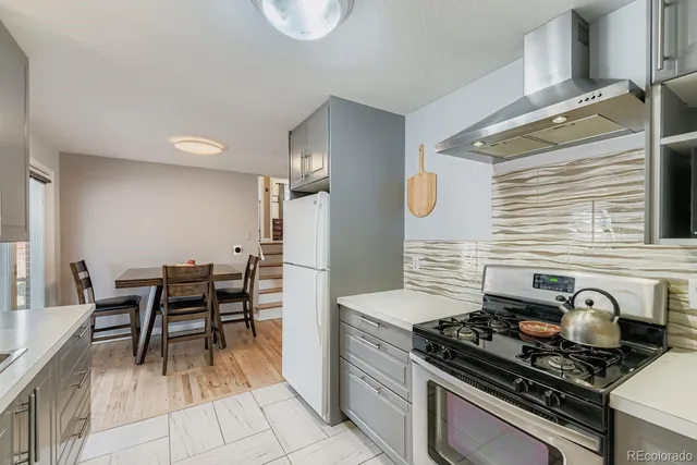 a kitchen with a stove and white cabinets