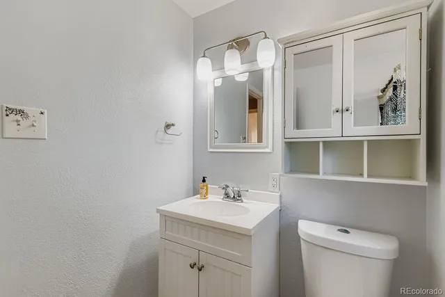 a bathroom with a toilet a sink and mirror