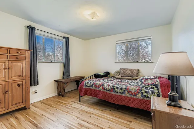 a bedroom with a bed wooden floor and window