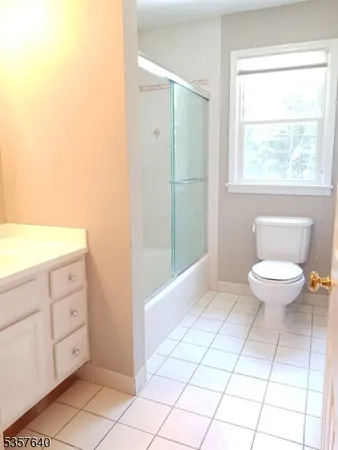 a bathroom with a toilet a sink and a window