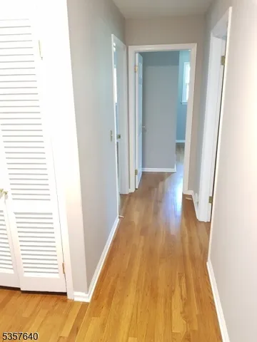 a view of empty room with wooden floor