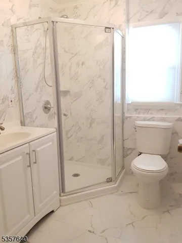 a bathroom with a shower a toilet and a sink