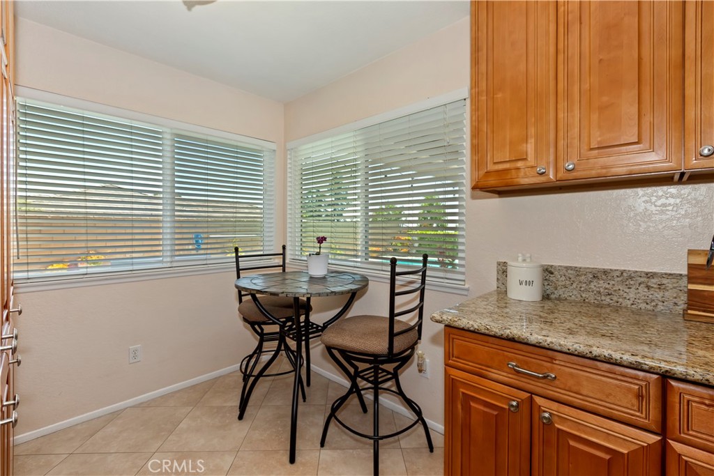 8527 Hillside Road Rancho Cucamonga, CA 91701 - Photo 16 of 50 a kitchen with stainless steel appliances granite countertop wooden cabinets and a table